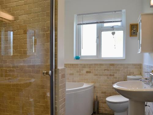 a bathroom with a sink and a toilet and a shower at Mill Haven in Dunster