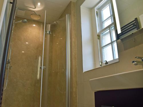 a bathroom with a shower and a sink and a mirror at Vanehouse Apartment in Osmotherley