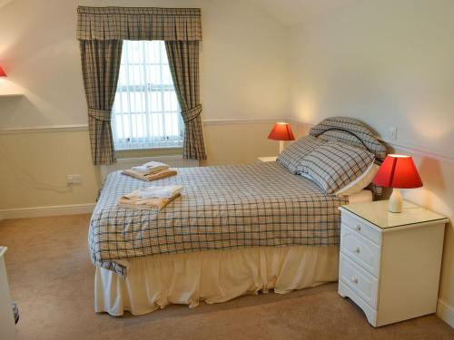 a small bedroom with a bed and a window at Vanehouse Apartment in Osmotherley