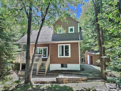 a house in the woods with trees at Chalet chez Antoine in Saint-Donat-de-Montcalm