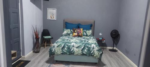 a bedroom with a bed with blue pillows at TJ Self-catering in Graaff-Reinet