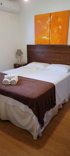 Pousada Amaryllis في تيرادينتيس: غرفة نوم بسرير كبير عليها منشفتين