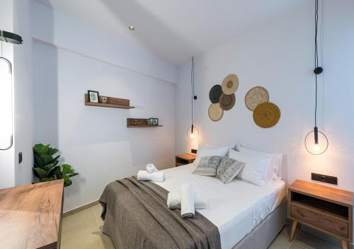 a white bedroom with a bed with towels on it at Noemie Apartments in Gerani