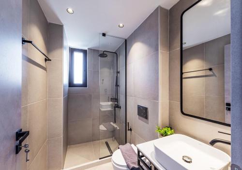 bagno con doccia, lavandino e servizi igienici di Noemie Apartments a Gerani