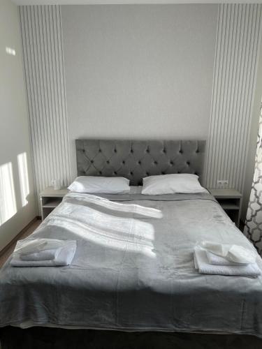 a bedroom with a bed with two towels on it at Готель-спа "Еліт" in Kolʼchyno