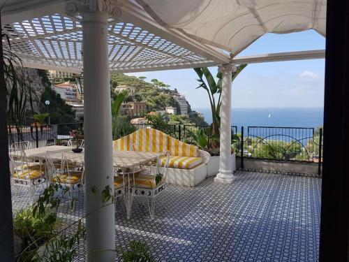 eine Terrasse mit einem Tisch, Stühlen und Meerblick in der Unterkunft La Casa di Giorgina in Sorrent