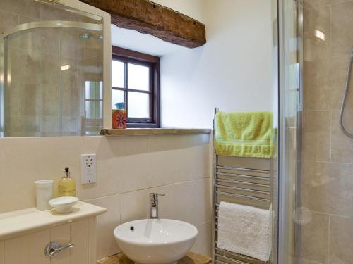 a bathroom with a sink and a shower at Tythe Barn in Froggatt