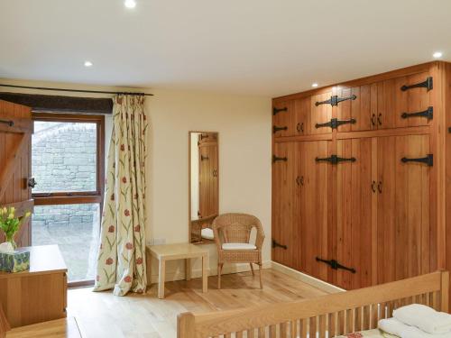 a room with wooden panels and a chair and a window at Tythe Barn in Froggatt