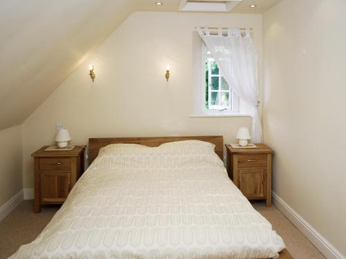 ein Schlafzimmer mit einem großen weißen Bett mit zwei Nachttischen in der Unterkunft The Old School House in Tideswell