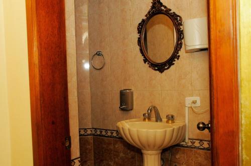 a bathroom with a sink and a mirror on the wall at Colony Inn Hotel in Ambato