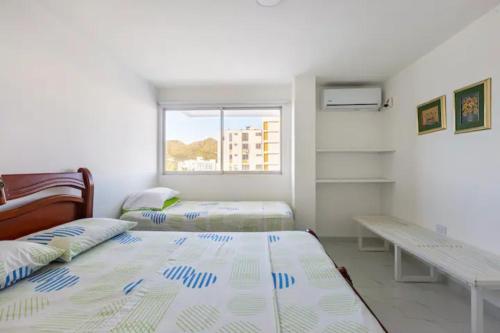 um quarto com 2 camas, uma secretária e uma janela em Apartamento Tacoa 703 em Santa Marta