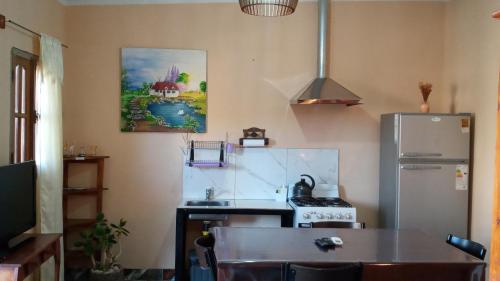 a kitchen with a refrigerator and a kitchen table at Casa y Departamentos Valle del Bermejo in Villa Unión