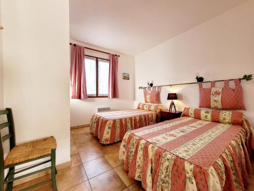 een slaapkamer met 2 bedden, een stoel en een raam bij Maison de 50 m2 a 400 m plage et piscine in Six-Fours-les-Plages