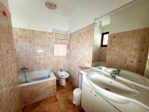 een badkamer met een bad, een wastafel en een toilet bij Maison de 50 m2 a 400 m plage et piscine in Six-Fours-les-Plages