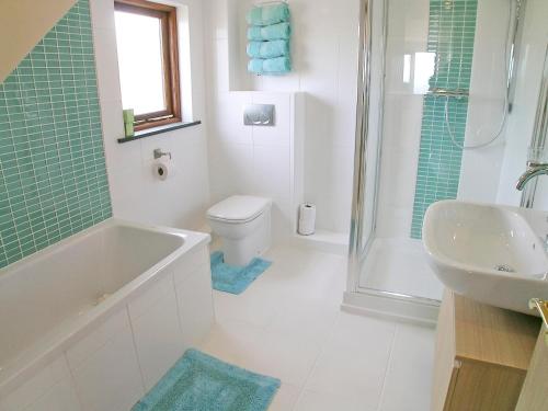 Lower Boscaswell的住宿－Stanhope Cottage，带浴缸、卫生间和盥洗盆的浴室