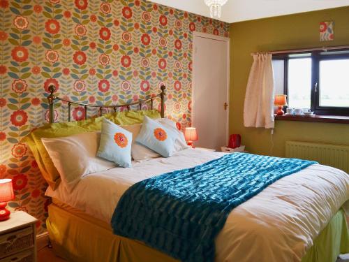 a bedroom with a bed with a colorful wall at Sea View in Shilbottle