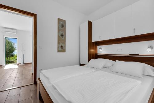 a bedroom with a white bed and a large window at Villa Natura Makarska in Makarska