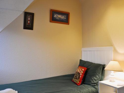 um quarto com uma cama com uma almofada vermelha em Bakehouse Cottage em Balnald