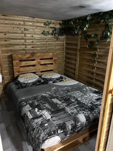 ein Schlafzimmer mit einem Bett in einem Holzzimmer in der Unterkunft Appartement 2 chambres in Brignoles