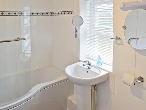 a white bathroom with a sink and a bath tub at Baytree Cottage 2 in Birch