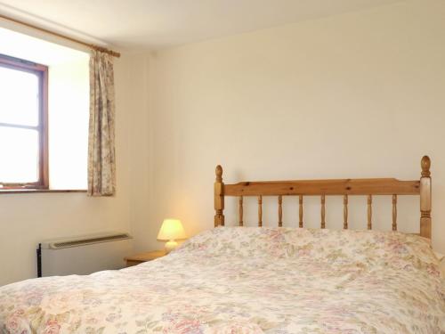 Schlafzimmer mit einem Bett und einem Fenster in der Unterkunft Challeys Cottage - E2378 in Banwell