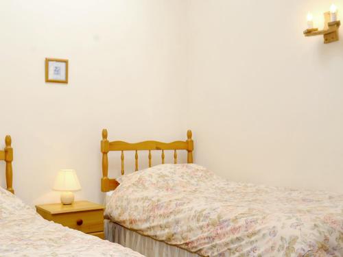 ein Schlafzimmer mit 2 Betten und einer Lampe auf einem Tisch in der Unterkunft Challeys Cottage - E2378 in Banwell