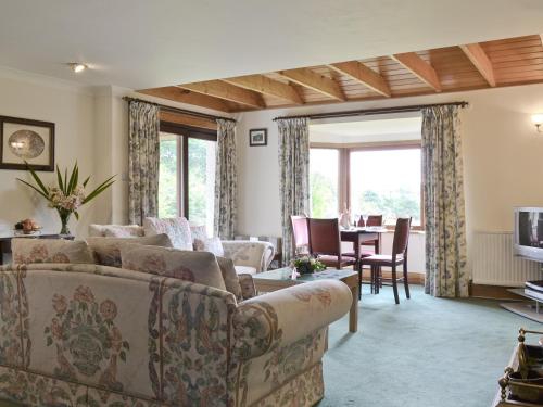 a living room with couches and a table with a television at Loch Alsh Cottage - Uvo in Balmacara