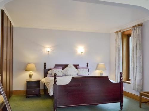 a bedroom with a large bed and two lamps at Loch Alsh Cottage - Uvo in Balmacara