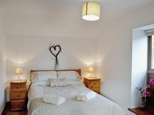 a bedroom with a bed with two night stands and two lamps at Y Stabl-w43382 in Cilybebyll