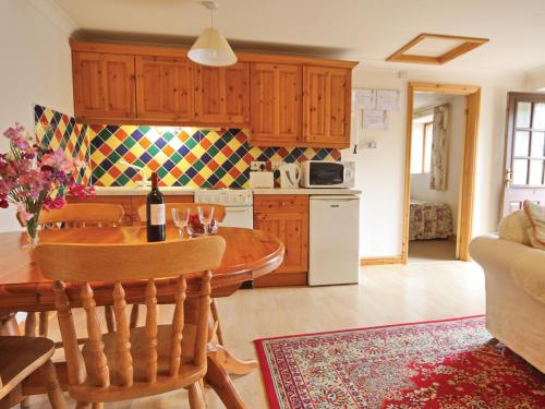 a kitchen with a wooden table and a dining room at Hay Cottage in Hoarwithy