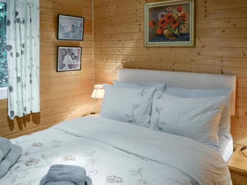 a bedroom with a white bed with wooden walls at Trewartha-by-chy in Crackington Haven