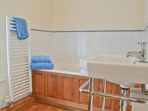 a bathroom with a sink and a bath tub at Grooms Cottage in Westleigh