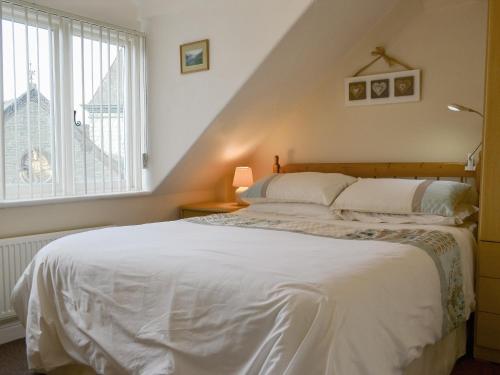 - une chambre avec un lit blanc et une fenêtre dans l'établissement Blencathra, à Keswick