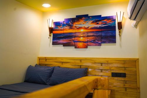 a bench in a room with paintings on the wall at Banyan Villa Maldives Dhangethi in Dhangethi