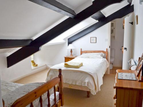 een slaapkamer met een groot bed en een raam bij The Coachman's Cottage in Alston