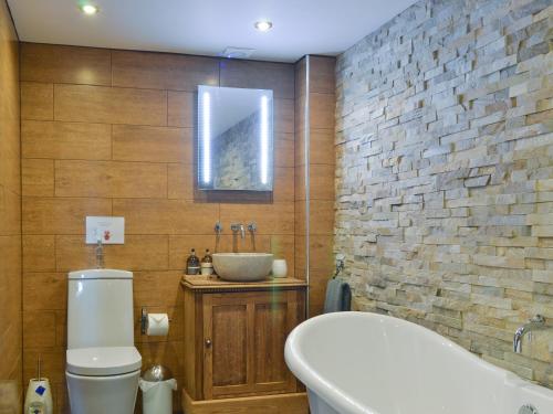 uma casa de banho com um lavatório, um WC e uma banheira em The Vestry em Cyffic