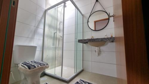 y baño con ducha, aseo y espejo. en Casa praia do Francês, en Marechal Deodoro