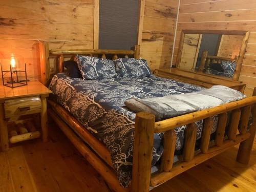 a wooden bed in a room with a mirror at Cozy Creekside Cabin in the heart of Hocking Hills in Laurelville