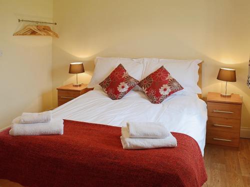 a bedroom with a white bed with two pillows at The Cart Shed in High Halstow