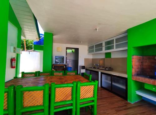 een groene keuken met een houten tafel en stoelen bij Bungalow in Holidays Beach Resort in Bolinao