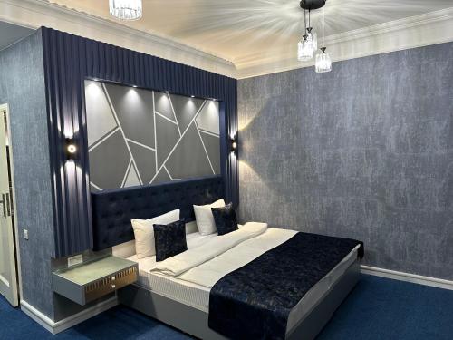 1 dormitorio con 1 cama grande y cabecero grande en Amber Hotel en Baku