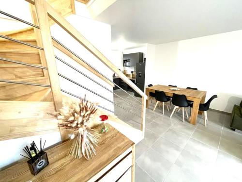 a kitchen and dining room with a staircase and a table at Villa 8 personnes bord de mer climatisée in Saintes-Maries-de-la-Mer