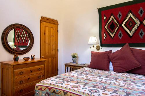 a bedroom with a bed and a mirror and a dresser at Las Brisas de Santa fe in Santa Fe