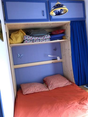 mały pokój z łóżkiem i niebieską zasłoną w obiekcie Beau studio plus, refait à neuf, tout confort, classé 3 étoiles par le comité départemantal du tourisme de la Haute Garonne w mieście Luchon