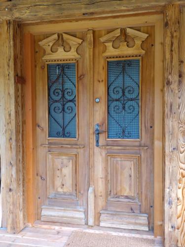 two wooden doors with stained glass windows on a house at Biohof Prem in Sankt Kathrein am Offenegg