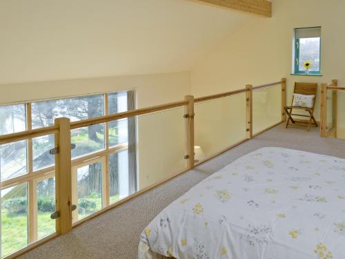 a bedroom with a bed and a large window at Kingfisher Lodge in Hainford