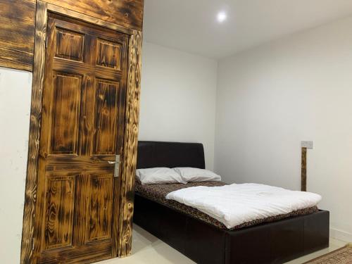 een slaapkamer met een houten deur en een bed bij Happy house in Birmingham