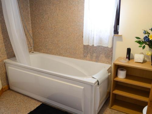 a white bath tub in a bathroom with a window at Kimberly Cottage in Alness