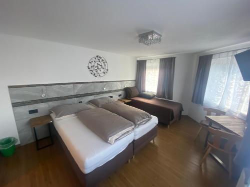 a bedroom with a large bed and a couch at Haus Eder Steiner in Saalbach Hinterglemm