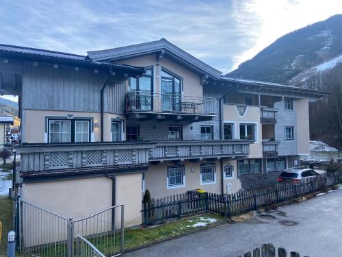 a large white house with balconies and a fence at Haus Eder Steiner in Saalbach Hinterglemm